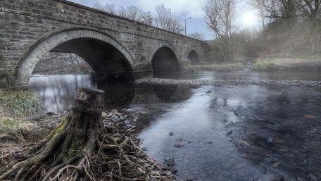 Tranquil River Under a Stone Bridge wallpaper