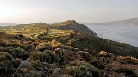 Serene Coastal Landscape with Rolling Hills and Water View wallpaper