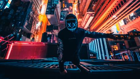 Neon masked guy climbing building wallpaper