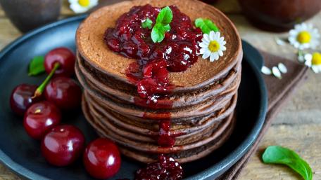 Delicious Chocolate Pancakes with Berry Topping and Fresh Mint wallpaper