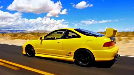 Vibrant Yellow Car on a Desert Road wallpaper