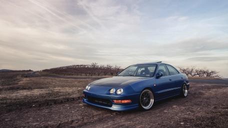Classic Blue Car Against Scenic Landscape wallpaper