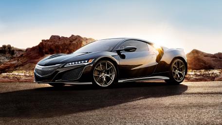 Sleek Black Sports Car Against a Scenic Backdrop wallpaper