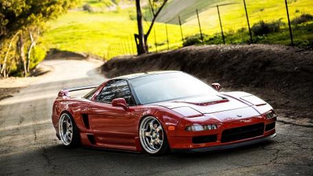 Sleek Red Sports Car on a Scenic Roadway wallpaper
