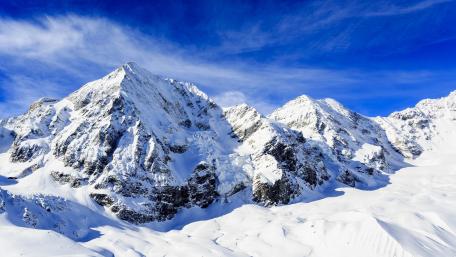 Majestic Snow-Capped Peaks Under Blue Sky wallpaper