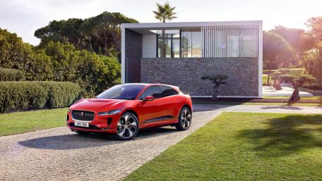 Sleek Red Electric SUV in Modern Luxury Setting wallpaper