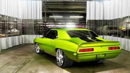 Vibrant Green Muscle Car in Warehouse Setting wallpaper