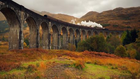 Majestic Train Journey Through Scenic Hillside wallpaper