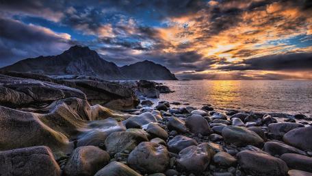 Serene Sunset Over Rocky Shoreline wallpaper