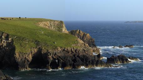 Majestic Coastal Cliffs Embracing the Sea wallpaper