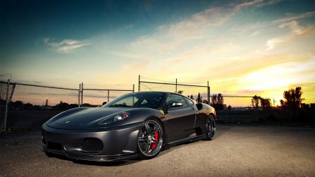 Sleek Sports Car Under a Sunset Sky wallpaper