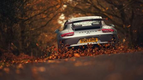 Sleek Silver Porsche on Autumn Roadscape wallpaper