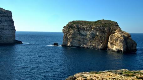 Breathtaking Coastal Rock Formation Under Clear Blue Skies wallpaper
