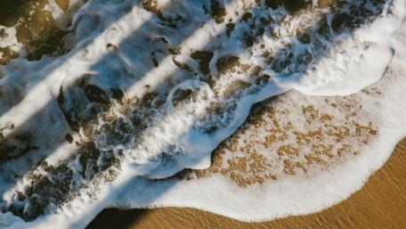 Foamy waves from above wallpaper
