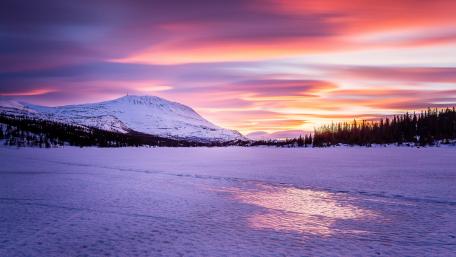 Serene Winter Dawn Over Frozen Lake wallpaper
