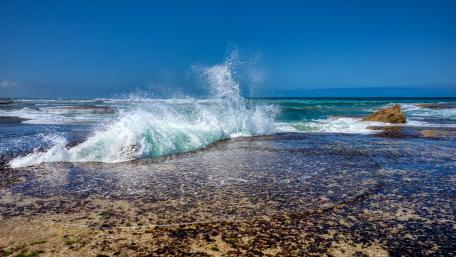 Serene Waves Under a Bright Blue Sky wallpaper