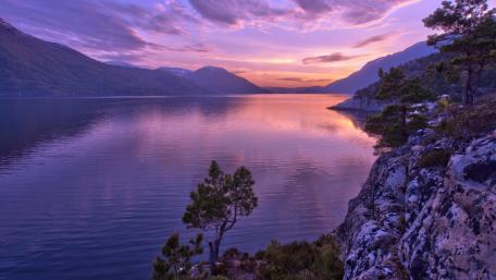 Serene Purple Sunset Over Tranquil Lake wallpaper