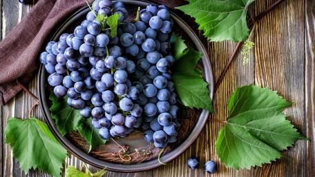 Vibrant Grapes on a Wooden Table wallpaper