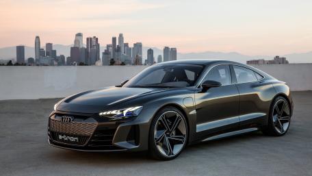 Sleek Electric Luxury Car Against City Skyline wallpaper