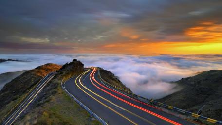 Serene Road through Misty Mountains at Sunset wallpaper