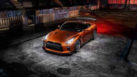 Sleek Orange Sports Car in Urban Setting wallpaper