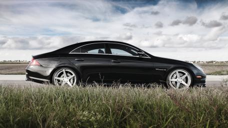 Sleek Black Luxury Car in Nature Setting wallpaper