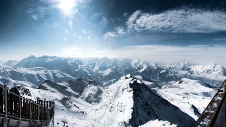 Majestic Snow-Capped Mountain Range Overlooking a Winter Wonderland wallpaper