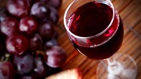 Elegant Glass of Red Wine with Grapes wallpaper