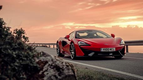 Red Supercar on Scenic Road at Sunset wallpaper