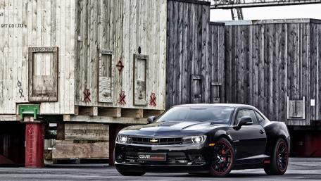 Sleek Black Muscle Car in Urban Setting wallpaper