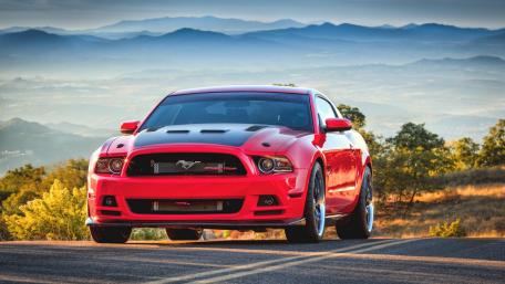 Bold Red Mustang on Scenic Roadway wallpaper