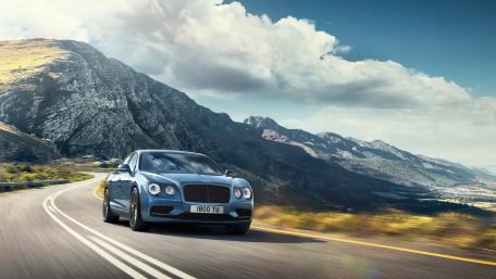 Sleek Luxury Car on Scenic Mountain Road wallpaper