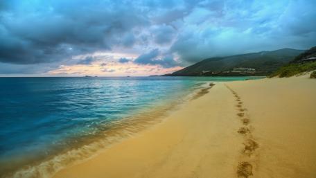 Tranquil Beach Under Dramatic Skies wallpaper
