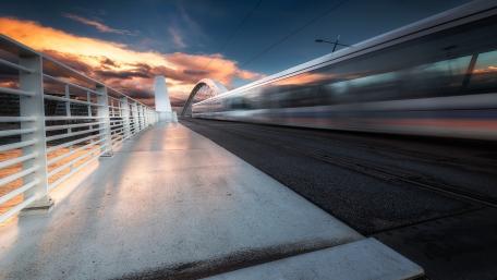 Vibrant Sunset Over Urban Bridge and Transit System wallpaper