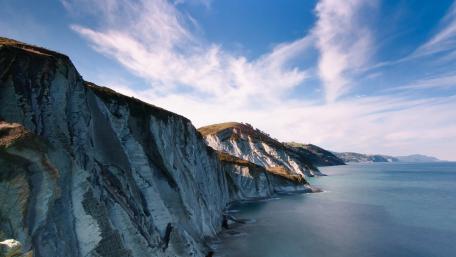 Majestic Coastal Cliffs Under a Blue Sky wallpaper