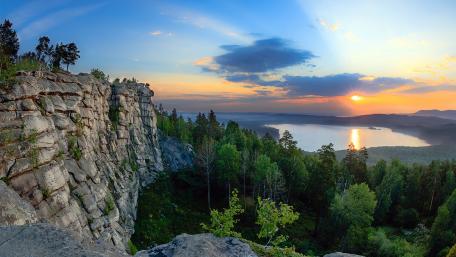 Serene Sunset Over Tranquil Lake and Lush Forests wallpaper