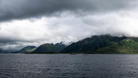 Majestic Stormy Mountains Over Serene Waters wallpaper