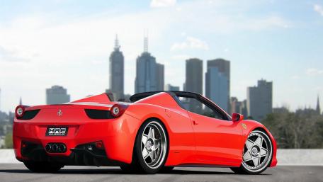 Sleek Red Sportscar Against Urban Skyline wallpaper