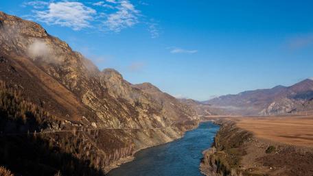 Serene River Valley Among Majestic Mountains wallpaper