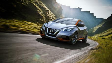 Sleek Car Driving Through Scenic Landscape wallpaper