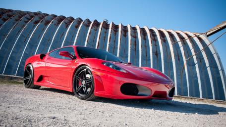 Sleek Red Sports Car in Vibrant Setting wallpaper
