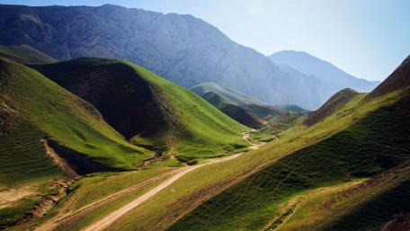 Lush Green Hills Under Clear Blue Sky wallpaper
