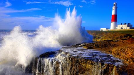 Majestic Lighthouse Amidst Powerful Waves wallpaper