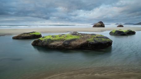 Serene Beachscape with Rocky Formations and Gentle Waves wallpaper