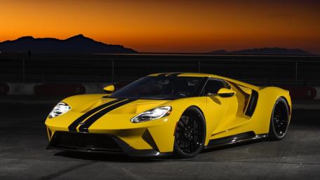 Sleek Yellow Supercar Against Sunset Skies wallpaper