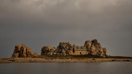 Serene Cottage Amidst Majestic Rocks wallpaper