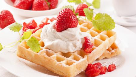 Delicious Waffles with Fresh Strawberries and Creamy Whipped Topping wallpaper