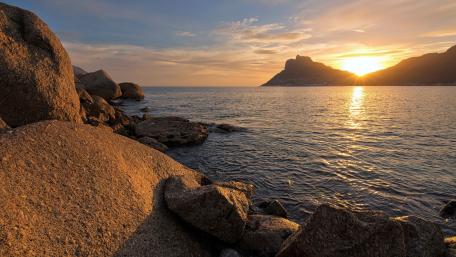 Golden Sunset Over Rocky Shoreline wallpaper