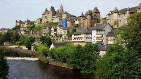Charming Riverside Town with Historic Architecture and Lush Greenery wallpaper