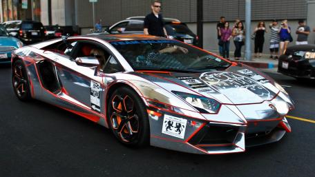 Sleek Mirrored Lamborghini on Vibrant City Streets wallpaper